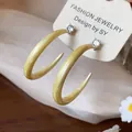 Primer plano de pendientes de aro en C de esmalte amarillo con circonitas brillantes - Grande / Amarillo