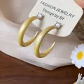Primer plano de pendientes de aro en C de esmalte amarillo con circonita brillante - Pequeño / Amarillo