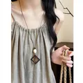 Detail of long leather cord necklace with vintage ethnic resin and acrylic pendant. - Double Ring Nested Style (HN12381-1) / Brown