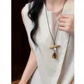 Detailed view of a retro ethnic resin pendant necklace with leather cord worn by a model - Oval Wood Combination Style (HN12379-1) / Brown