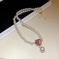 Detailansicht einer Luxus-Perlenkette mit rosa Herz-Zirkonia und Perlenanhänger - Weiß-Rosa