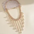 Detailed macro view of sparkling rhinestone fringe necklace with teardrop charms - Gold