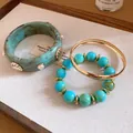 Close-up of vintage resin bangle with shell details and turquoise bead bracelet set - 3-Piece Jewelry Set / Gold + Blue