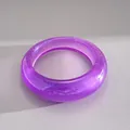 Dettaglio di un bracciale rigido in acrilico viola traslucido con glitter argento interni. - Viola