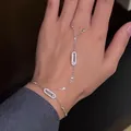 Elegante dettaglio di un bracciale a mano in argento con motivi geometrici in zircone. - Argento