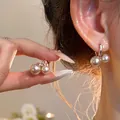 Primer plano de elegantes pendientes de aro con doble perla vintage en la oreja - Aro de Doble Perla / Oro Café Claro