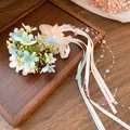 Elegant floral hair clip featuring pastel ribbons and iridescent pearls on a rustic wooden tray. - Blue / Duckbill Hair Clips