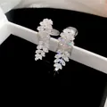Detailed close-up of sparkling leaf-shaped cubic zirconia ear clips inside a jewelry box - Clip-On Earrings / Silver