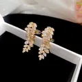Close-up detail of 18k gold-plated leaf ear clips featuring sparkling marquise zircons - Clip-On Earrings / Gold