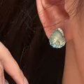 Makroansicht eines eleganten Muschelohrrings aus Harz mit funkelnden Zirkonen. - Muschel-Ohrringe / Ein Paar / Silber-Blau