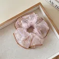 Close-up detail of a pink chiffon scrunchie with brown polka dots and elegant ruffled edges - White Coffee Polka Dot