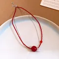 Vista dettagliata della collana di perle rosse in acciaio con un ciondolo a fiore - Collana-Rosso