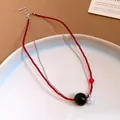 Dettaglio della collana di perline in acciaio inox con sfera nera e fiore - Collana-Rosso-Nero