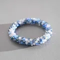 Macro view showing the intricate detail of blue and white braided crystal beads and shine - Bracelet / Blue-Grey