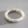 Close-up of sparkling multicolor crystal beads on a textured grey background - Bracelet / Green-Coffee