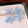 Close-up detail of elegant blue marble effect flower earrings with sparkling crystals - Heart Flower Tassel Style / Blue