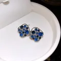 Nahaufnahme silberner Rautenohrstecker mit funkelnden blauen und dunkelblauen Steinen - Silberner Ohrstecker - Silber - Blau