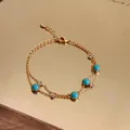 Detail of a vintage gold bracelet featuring round turquoise stones and clear crystals. - Gold-Blue