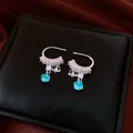 Detailed shot of silver ear cuff with sparkling zircons and square blue crystal pendant - One Pair / Silver-Blue