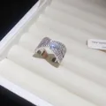 Dettaglio di un elegante anello incrociato color argento con zirconi scintillanti - Anello Forma a X Incrociato No.4 / Argento
