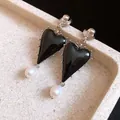 Detailed close-up of elegant black resin heart earrings featuring delicate pearl drop accents - Black