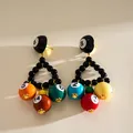 Detail view of colorful resin billiard ball triangle earrings featuring vibrant digital numbers - Triangular Billiard Dopamine Style / Black Multicolor