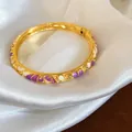 Détail d'un jonc plaqué or avec d'élégantes fleurs en émail violet et des accents de cristal - Or-Blanc-Violet