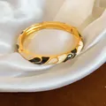 Vue rapprochée d'un bracelet doré avec un élégant motif émaillé noir et blanc chic. - Or-Blanc-Noir