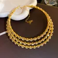 Detailed view of a gold-plated three-layer crystal choker necklace with sparkling stones. - Gold