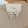 Detailed macro view of silver bowknot pearl earrings with heart stud on a display card - Heart Bow Style (3#)