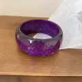 Detail view of a purple resin bangle featuring embedded sparkling star-shaped glitter sequins - Purple