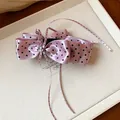 Gros plan d'une pince à cheveux à nœud rose à pois avec cristal et rubans - Pince Torsadée / Violet