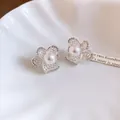 Macro detail of elegant French vintage hollow flower earrings featuring pearls and zircons - Silver