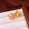 Close-up of minimalist 18k gold-plated hoop earrings with a brushed texture finish - Huggie Style (HE33969) / Gold