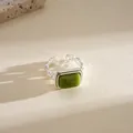 Close-up of a geometric silver ring featuring a square olive green resin center stone - Open Ring / Green
