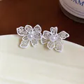 Dettaglio degli orecchini a lobo a fiore traforato bianco con perle su un piatto di ceramica - Bianco