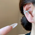 Funkelnde silberne Schleifen-Ohrklemme mit Zirkoniasteinen am Ohr einer Frau - Rechtes Ohr Einzelstück (HE31662) / Silber