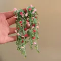 Handheld detail of long green beaded tassel earrings with pink flower charms - Handmade Beaded Flowers (6#)