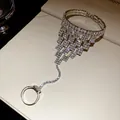 Dettaglio di un bracciale con anello e frange quadrate di strass dal look lussuoso - Catena integrata anello e bracciale / Argento