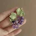 Close-up of grape-shaped earrings with purple beads and green textured leaves - Grape Shape Tassel (30#)