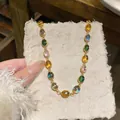 Gros plan d'un bracelet en résine vintage avec pierres ovales colorées sur papier - Collier Or Coloré