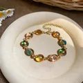 Vue détaillée d'un bracelet vintage doré orné de perles ovales colorées en résine - Bracelet-Or-Multicolore