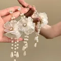 Close-up of elegant lace flower earrings featuring pearl tassels and zircon studs - Silver Earring Post-White