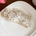 Close-up of a floral print fabric bow hair clip with lace trim on a white plate - Floral Bow Twisting Clip / Single Piece / Beige