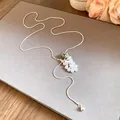 Detailed view of the teardrop pearl and spotted stone on a long silver necklace - Dalmatian Jasper Style / Silver