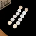 Close-up of elegant metallic multi-disc dangling earrings with premium brushed finish - Earrings (925 Silver Pin - Silver)