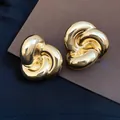 Vista macro de pendientes de botón vintage de flor retorcida dorada con acabado pulido brillante - Dorado
