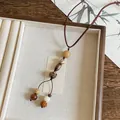 Detailed macro view of a vintage New Chinese style wood bead necklace with handmade pendants - Coffee and White