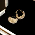 Nahaufnahme von Vintage-Creolen mit Perlenreihen und funkelnden Strasssteinen - Alternating Pearl Rhinestone Style / Gold