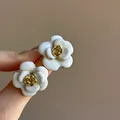 Close-up of elegant French-style white enamel flower earrings with gold rose center - French Enamel Flower Style (HE32233-1-) / Gold-White